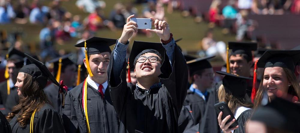 Student taking selfie at a graduation ceremony at Iowa State University